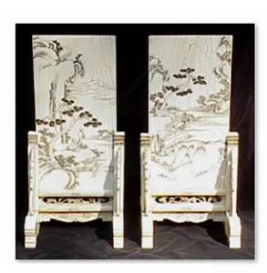 Pair of carved ivory-toned panels on stands